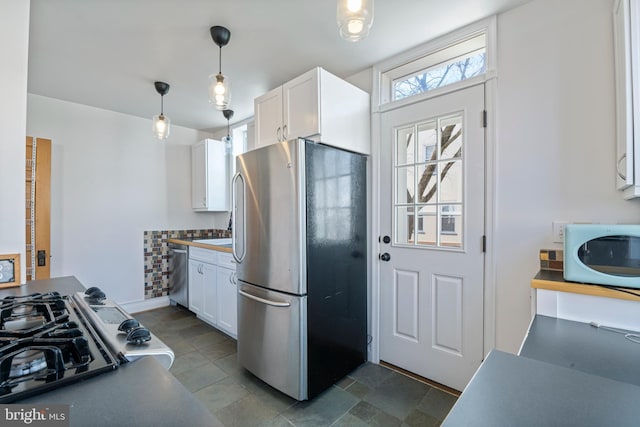 kitchen featuring white cabinetry, pendant lighting, and appliances with stainless steel finishes