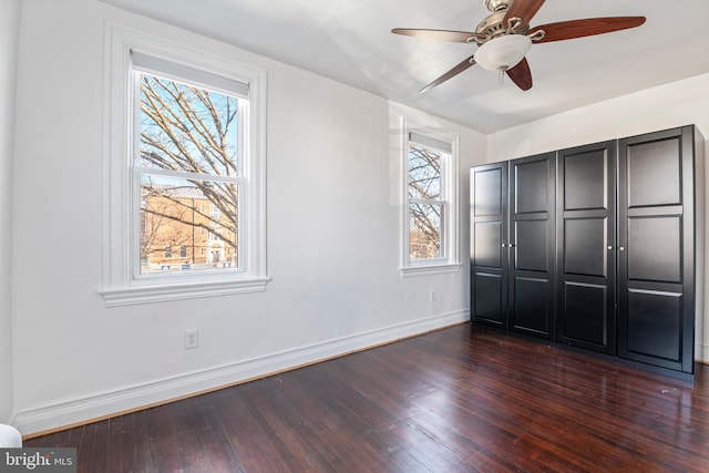 unfurnished bedroom with dark hardwood / wood-style flooring, a closet, and ceiling fan