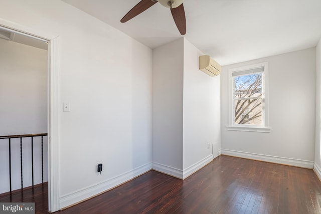 spare room featuring a wall unit AC, ceiling fan, and dark hardwood / wood-style floors