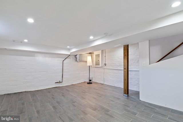 basement featuring wood-type flooring and electric panel