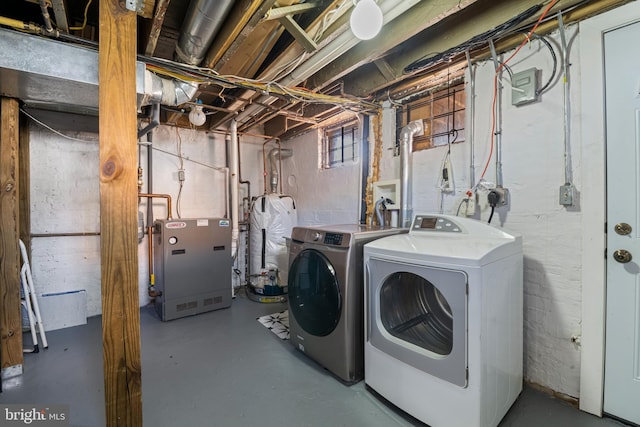 laundry area featuring water heater and washing machine and clothes dryer