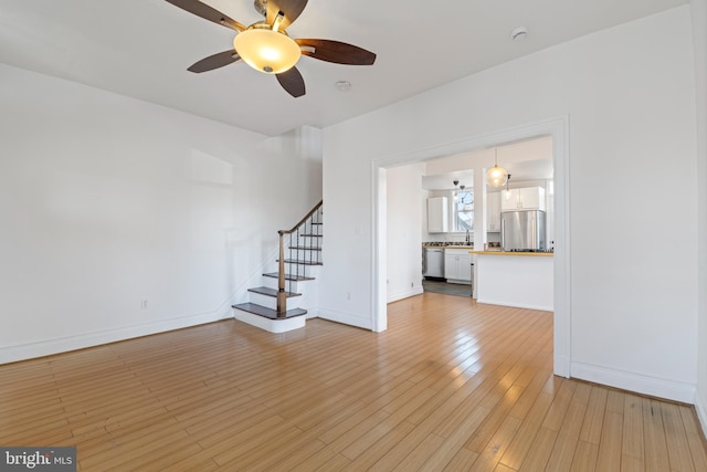 unfurnished living room with ceiling fan and light hardwood / wood-style floors