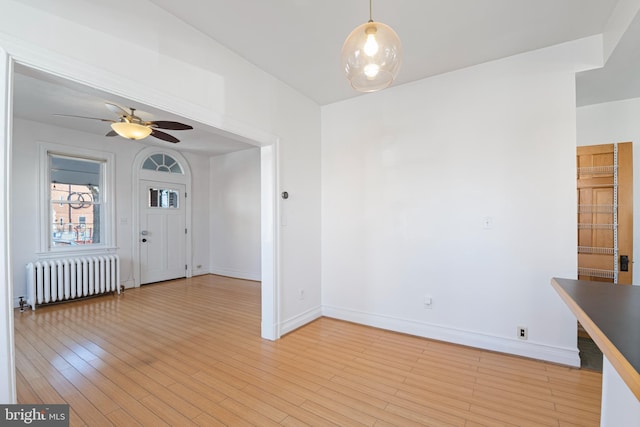 interior space featuring radiator heating unit, light hardwood / wood-style flooring, and ceiling fan