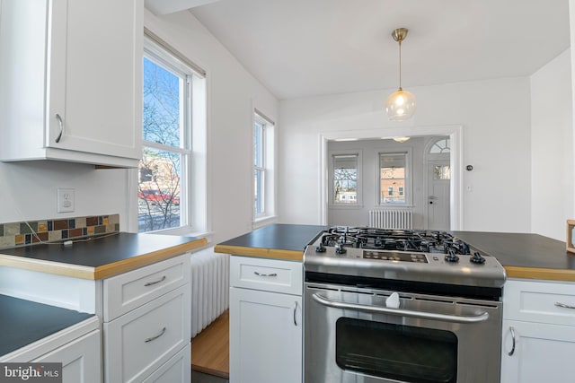 kitchen featuring white cabinetry, stainless steel range with gas cooktop, and hanging light fixtures