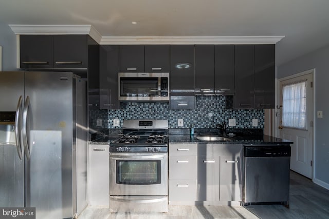 kitchen with dark stone countertops, sink, tasteful backsplash, and stainless steel appliances