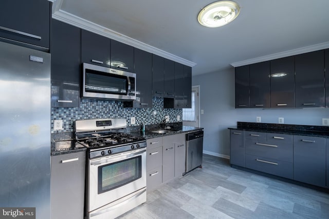 kitchen featuring sink, dark stone countertops, ornamental molding, appliances with stainless steel finishes, and decorative backsplash