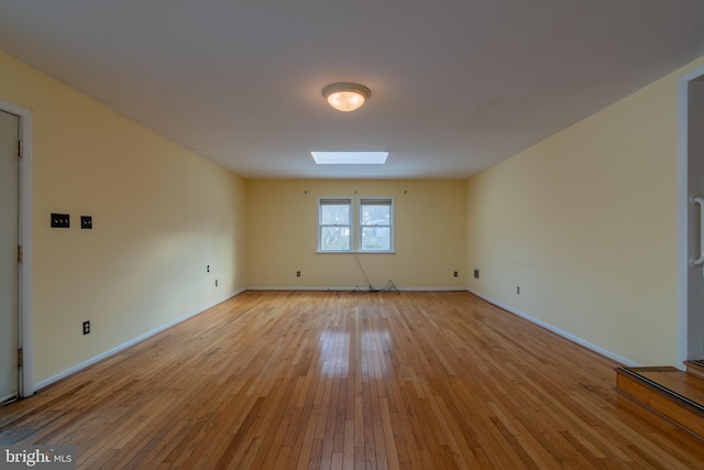 unfurnished room featuring light wood-type flooring and a skylight