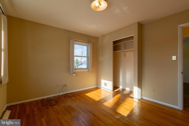 unfurnished bedroom with wood-type flooring and a closet