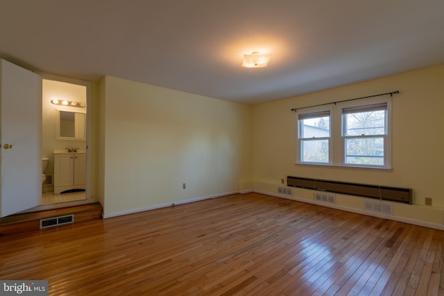 empty room with a baseboard radiator and wood-type flooring