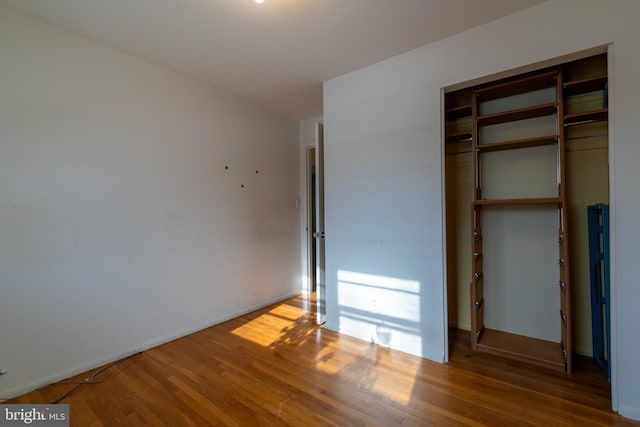 unfurnished bedroom featuring wood-type flooring and a closet