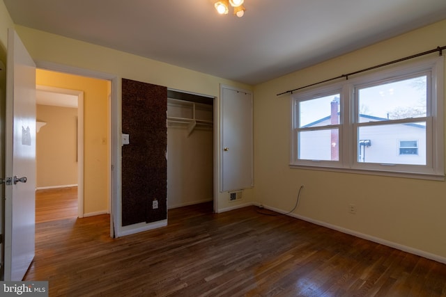 unfurnished bedroom with dark hardwood / wood-style floors and a closet