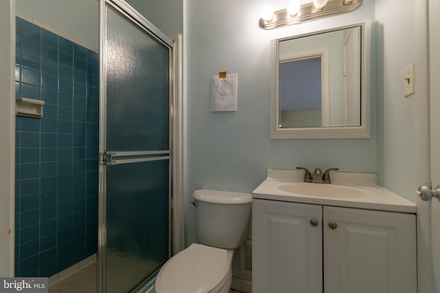 bathroom with a shower with door, vanity, and toilet