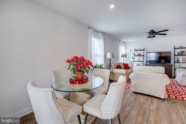 dining area with hardwood / wood-style flooring and ceiling fan