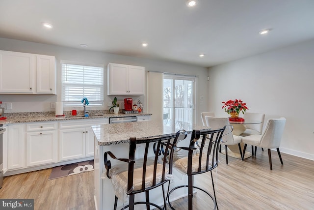 kitchen featuring white cabinetry, sink, plenty of natural light, and light hardwood / wood-style flooring