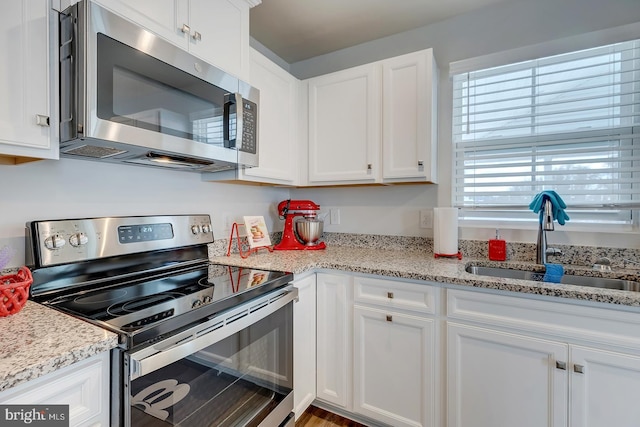 kitchen featuring white cabinets, light stone counters, sink, and stainless steel appliances