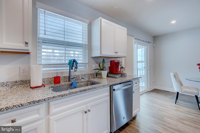 kitchen with light stone countertops, white cabinetry, sink, and stainless steel dishwasher