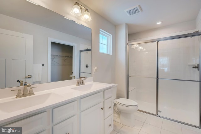 bathroom featuring tile patterned flooring, vanity, toilet, and walk in shower