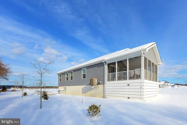 exterior space featuring central air condition unit and a sunroom