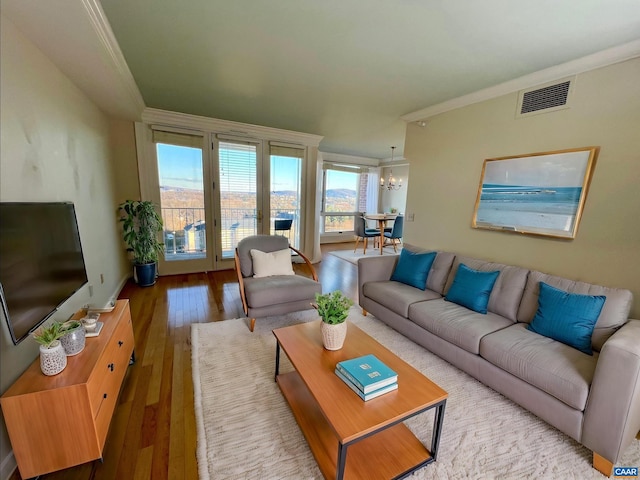 living room featuring hardwood / wood-style flooring, plenty of natural light, and ornamental molding