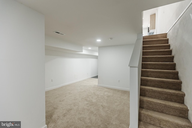 stairway featuring carpet flooring