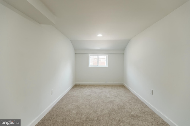 carpeted spare room with lofted ceiling