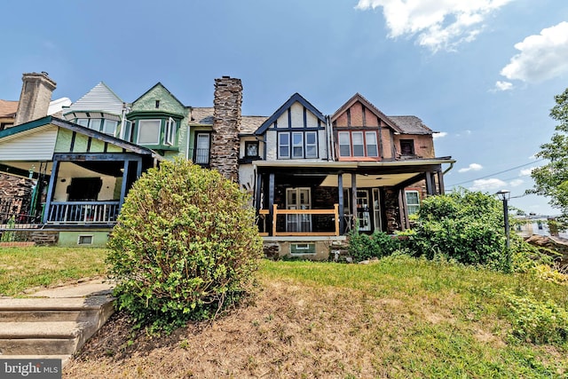 rear view of house featuring covered porch