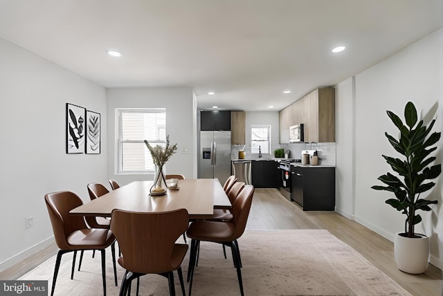 dining space featuring light hardwood / wood-style flooring and sink