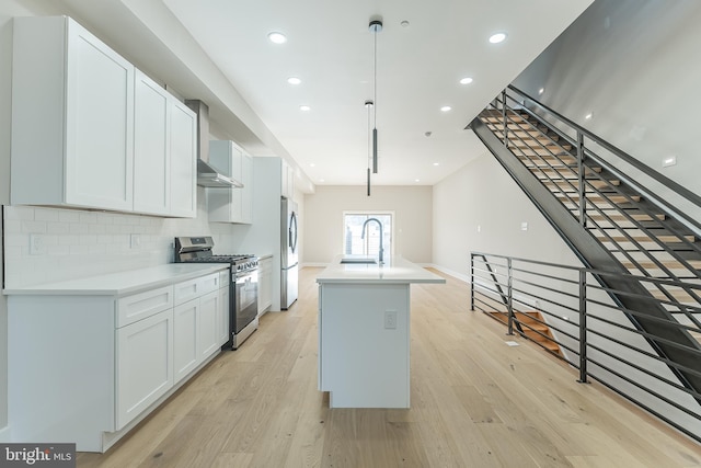 kitchen featuring stainless steel appliances, a kitchen island, backsplash, decorative light fixtures, and white cabinets