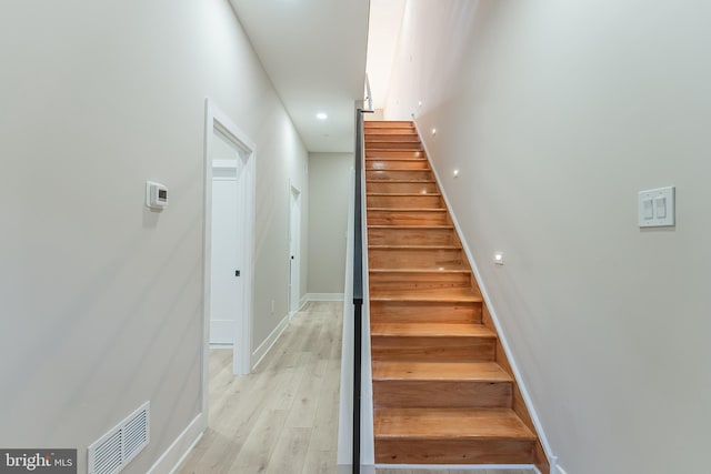 staircase with hardwood / wood-style flooring