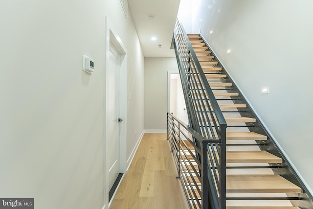 stairs featuring hardwood / wood-style floors