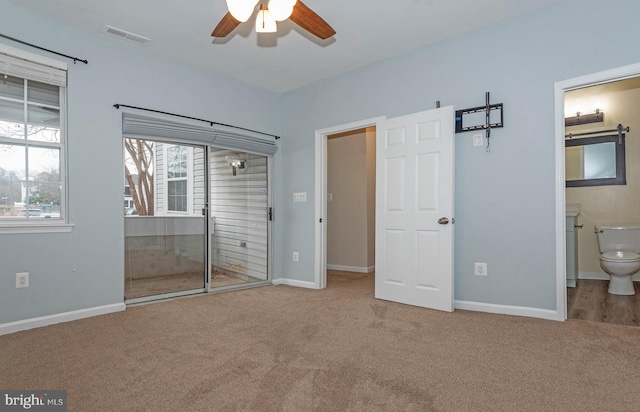 unfurnished bedroom featuring carpet, ceiling fan, ensuite bathroom, and a closet