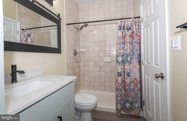 bathroom with hardwood / wood-style flooring, a shower with curtain, toilet, and vanity