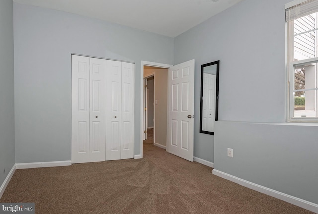 unfurnished bedroom with carpet flooring, a closet, and multiple windows