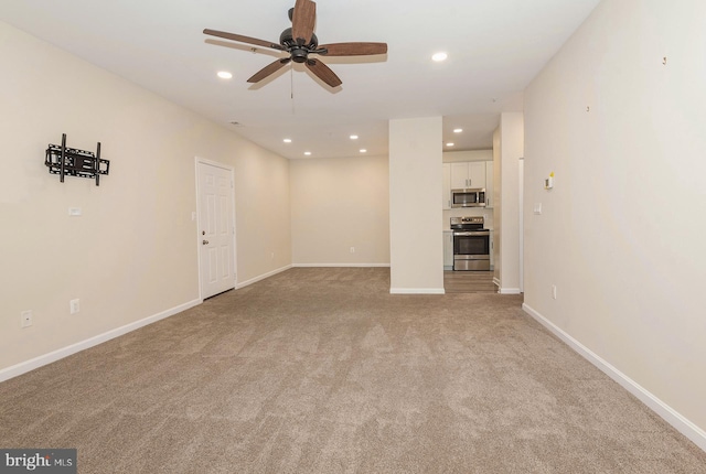 unfurnished living room with light colored carpet and ceiling fan