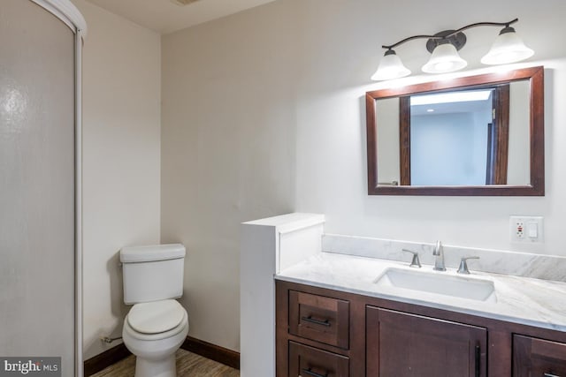 bathroom featuring vanity, wood-type flooring, and toilet