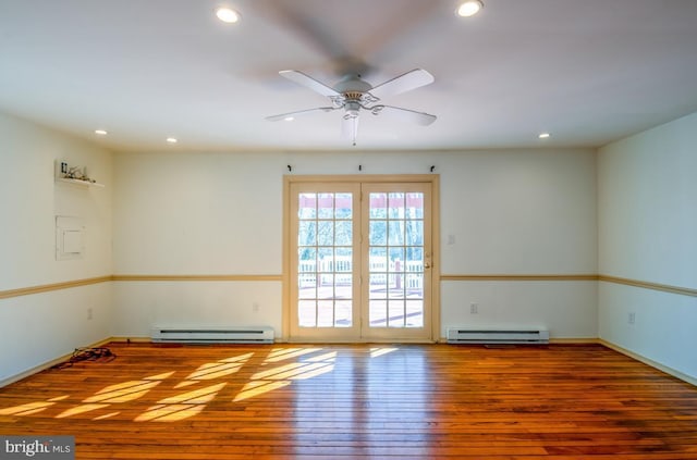 unfurnished room with hardwood / wood-style flooring, ceiling fan, and a baseboard heating unit