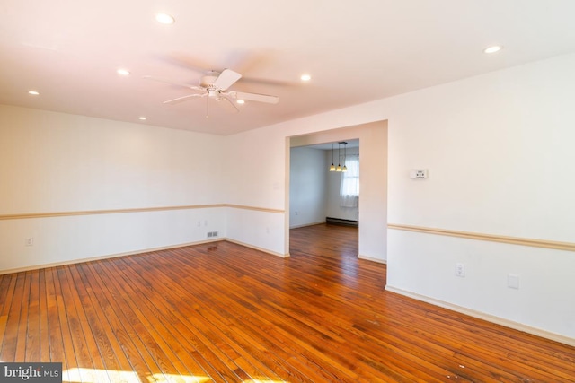 spare room featuring hardwood / wood-style flooring, ceiling fan, and a baseboard radiator