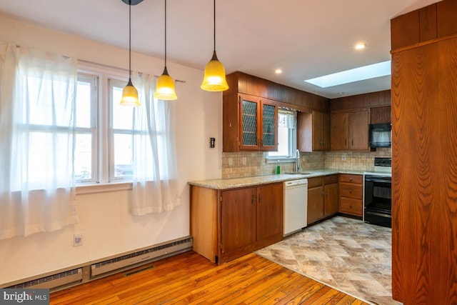 kitchen featuring electric range oven, a skylight, decorative light fixtures, a baseboard radiator, and white dishwasher