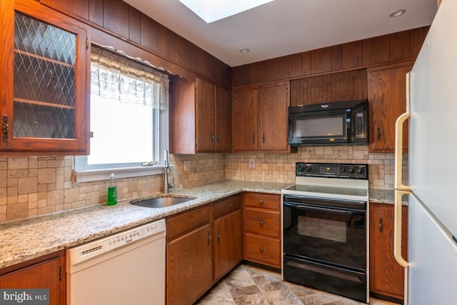 kitchen featuring sink, backsplash, black appliances, and light stone countertops