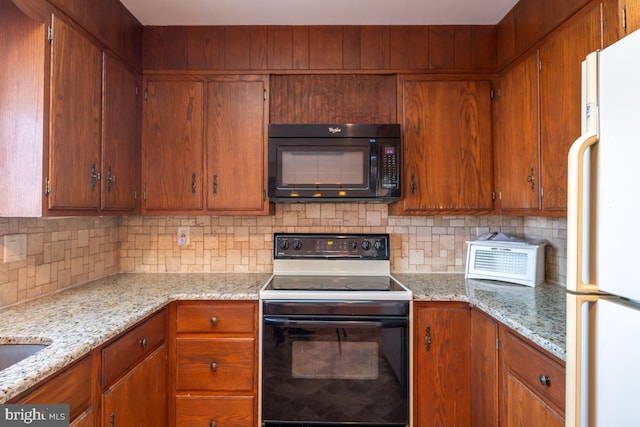 kitchen with backsplash, light stone countertops, and black appliances