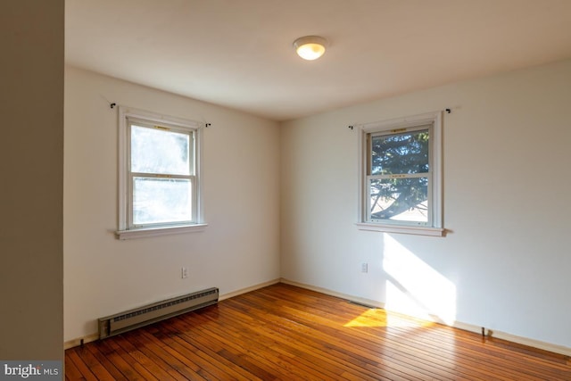 empty room with baseboard heating and wood-type flooring