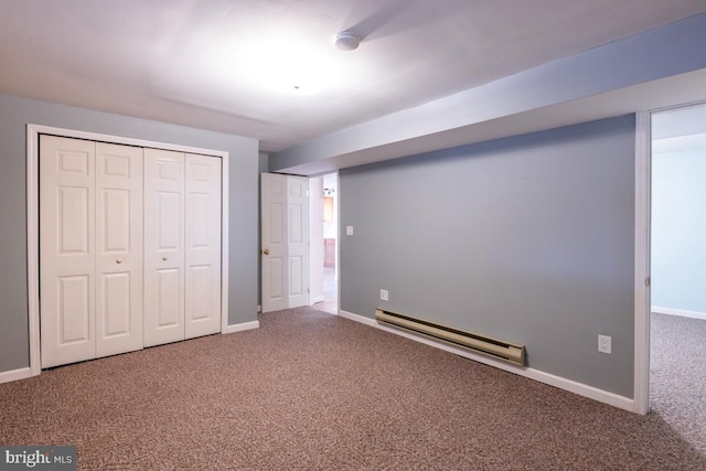 unfurnished bedroom with baseboard heating, a closet, and carpet