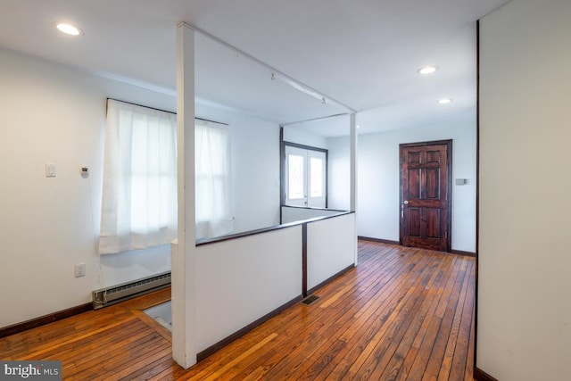 interior space with dark hardwood / wood-style floors and a baseboard heating unit