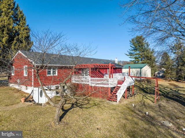 rear view of property with a yard and a deck