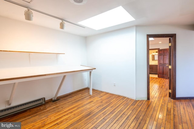 interior space featuring a baseboard radiator, wood-type flooring, and rail lighting