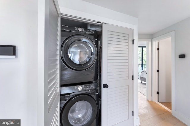 clothes washing area with light hardwood / wood-style floors and stacked washing maching and dryer