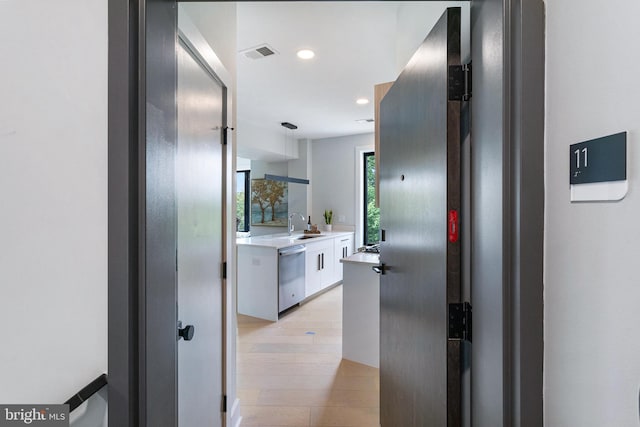 hall with sink and light hardwood / wood-style flooring