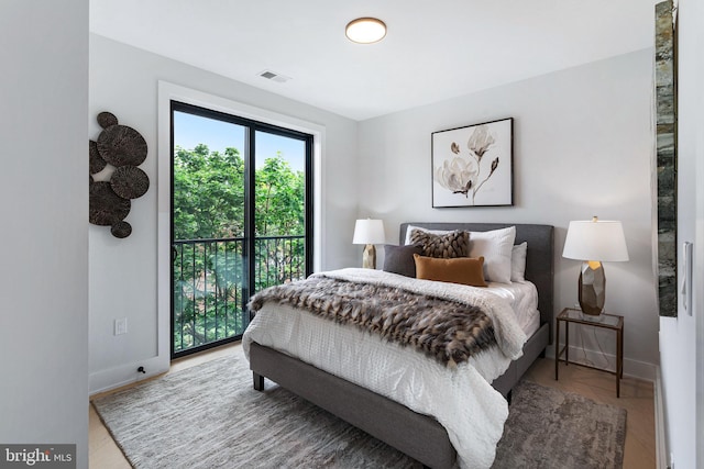 bedroom featuring hardwood / wood-style floors and access to outside