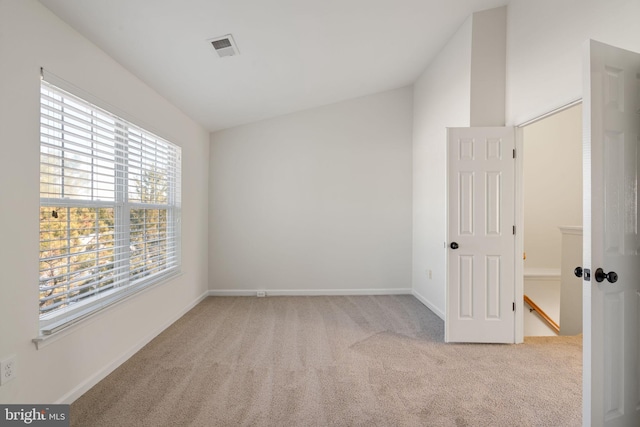 empty room with lofted ceiling and light carpet