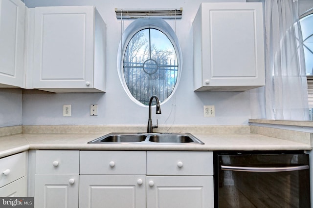 kitchen featuring sink, white cabinetry, and black dishwasher